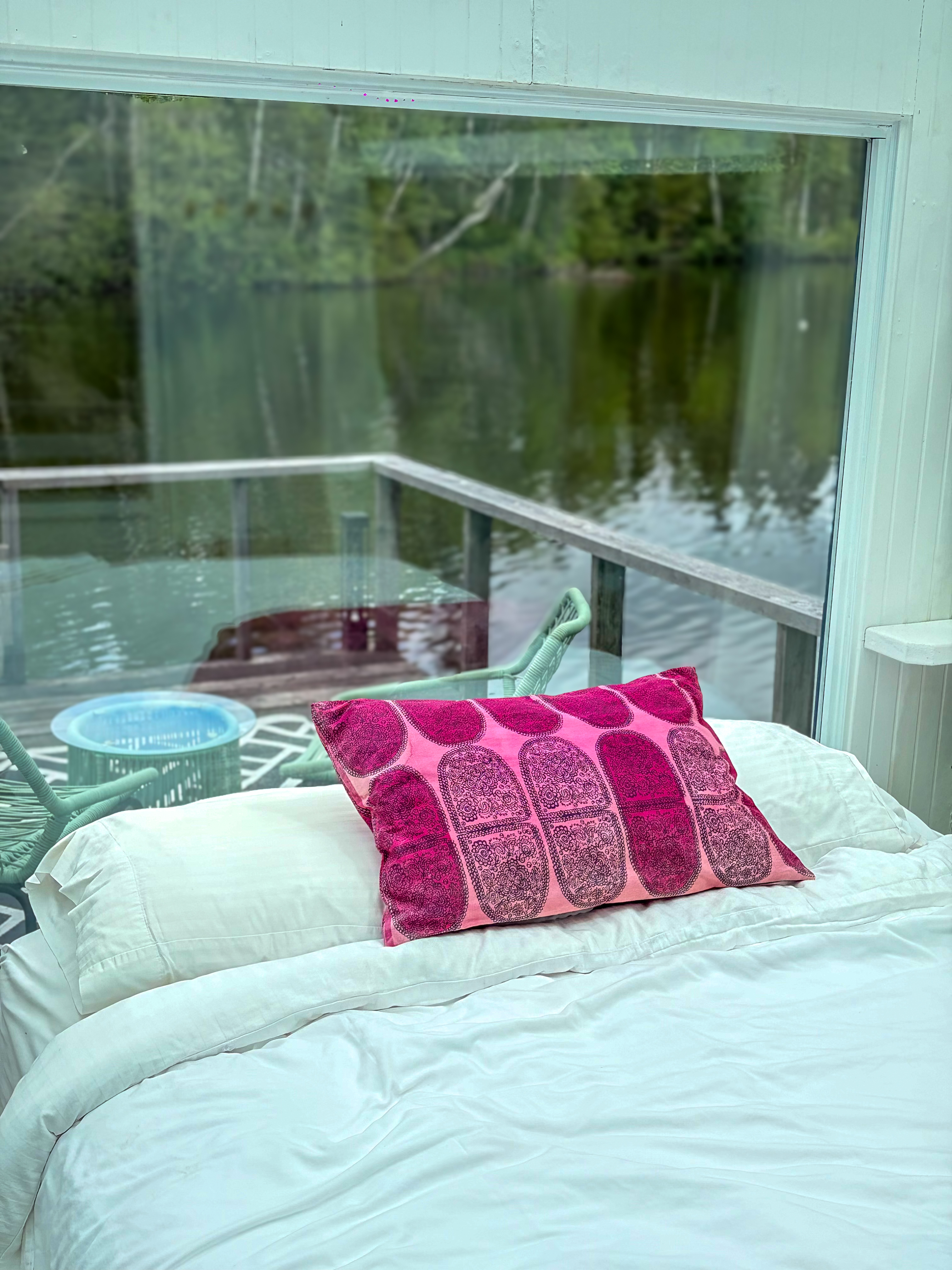 Lit de la Maison de Verre devant la baie vitrée donnant sur le lac