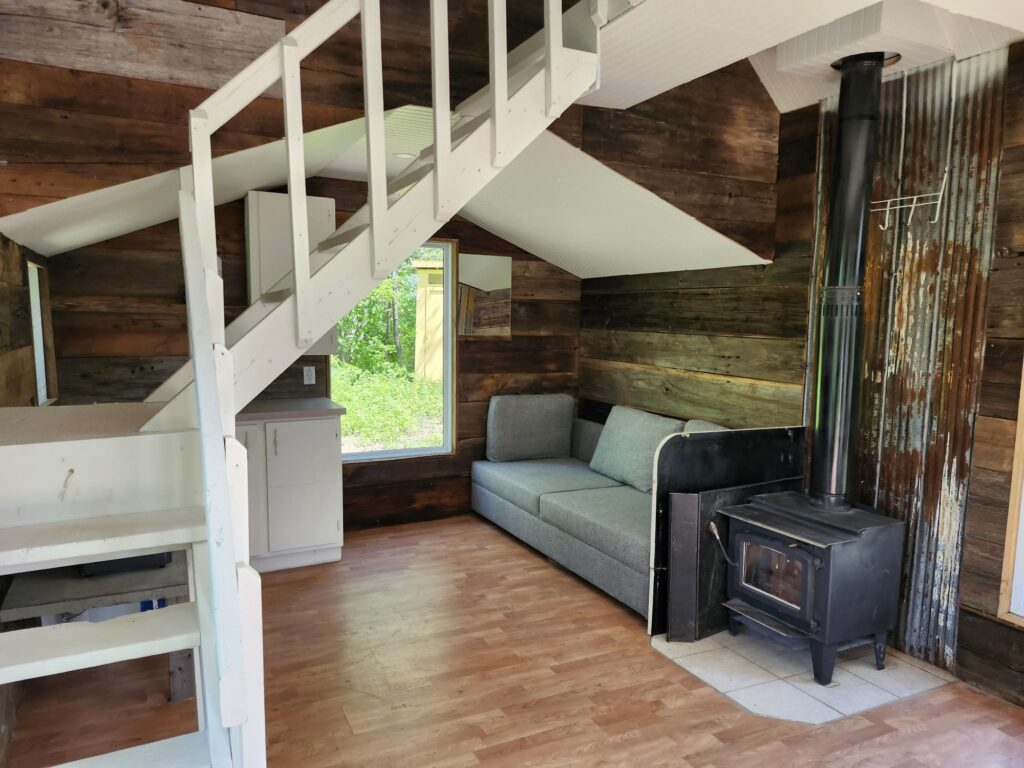 Intérieur avec poêle à bois et escalier menant à la mezzanine